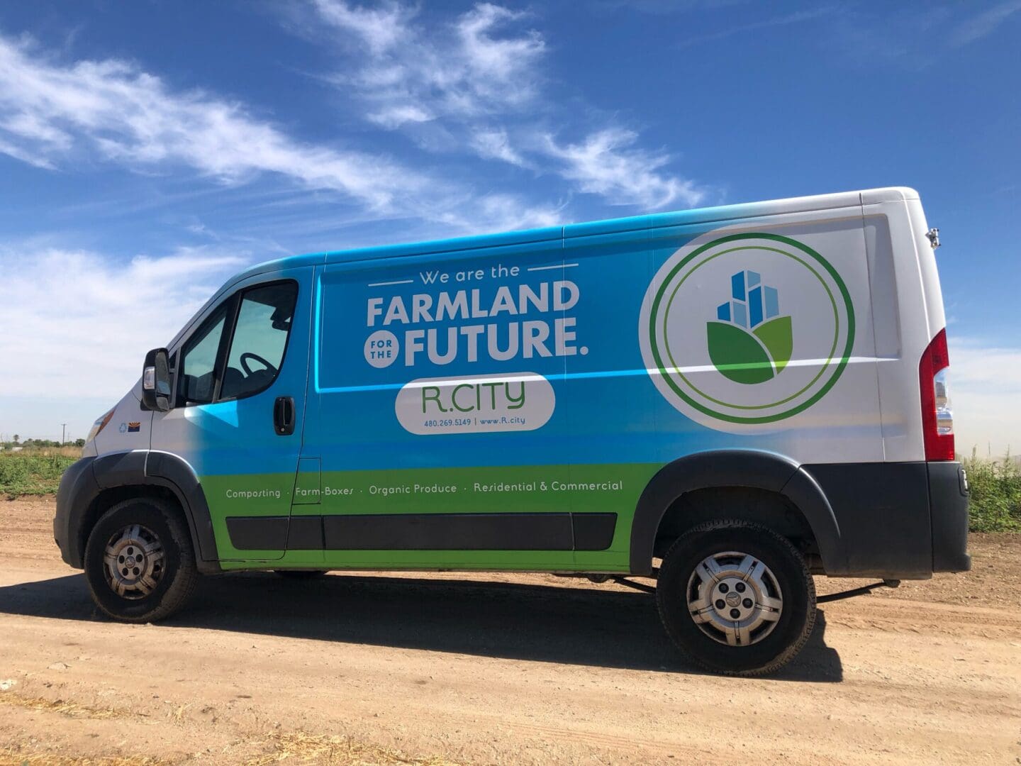 A blue and green van is parked on the side of the road.