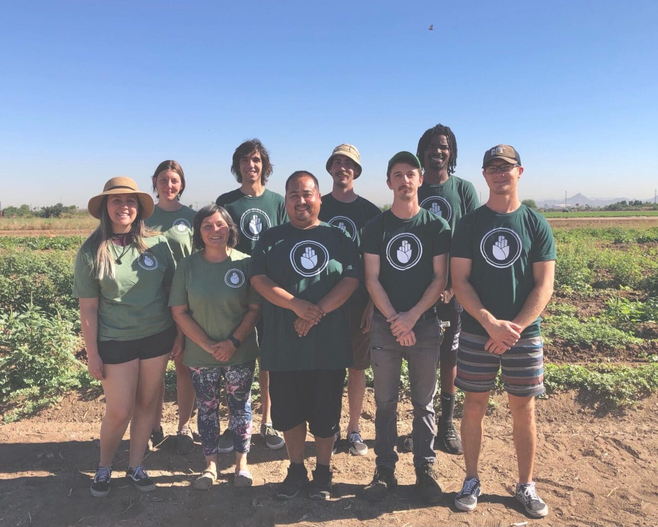 A group of people standing in the dirt.